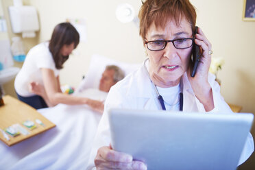 Arzt mit Mobiltelefon und digitalem Tablet im Krankenhauszimmer - ZEF000964