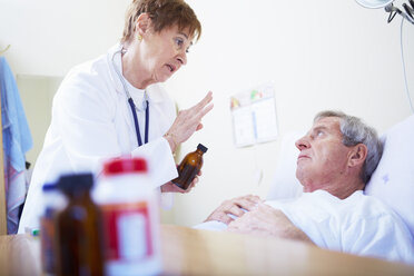 Doctor talking to senior man in hospital bed - ZEF000967