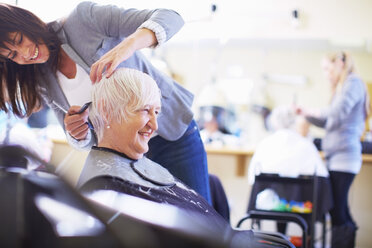 Friseurin schneidet Haare einer älteren Frau - ZEF001014