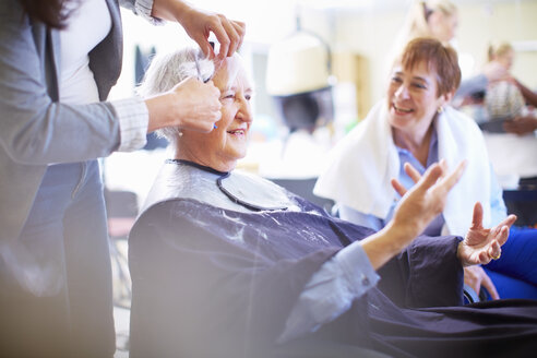 Friseurin schneidet Haare einer älteren Frau - ZEF001015