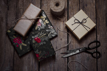 Wrapped christmas gifts, scissors and string on wooden table - CZF000170