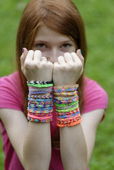 Girl with many self-made looms at her wrists - LBF000954