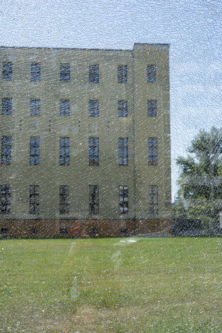 Deutschland, Berlin, Blick durch eine zerbrochene Glasscheibe auf eine Hausfassade, lizenzfreies Stockfoto