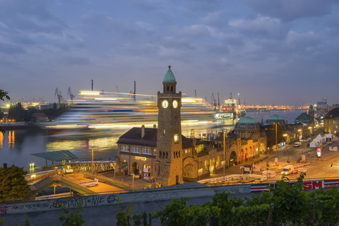 Deutschland, Hamburg, Uhrturm an den Landungsbrücken und einlaufendes Kreuzfahrtschiff am Morgen, lizenzfreies Stockfoto