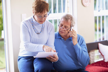 Älteres Ehepaar liest Dokument zu Hause - ZEF001059