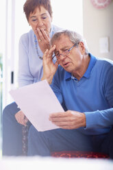 Schockiertes Seniorenpaar liest Dokument zu Hause - ZEF001062