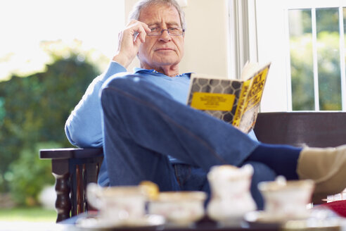 Älterer Mann liest zu Hause ein Buch - ZEF001070