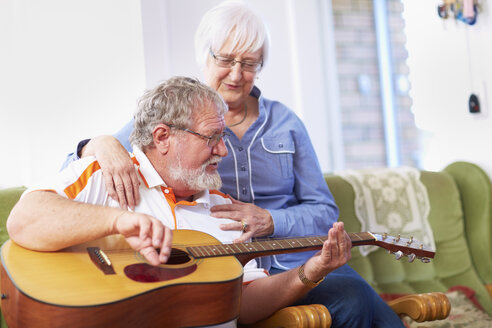 Älterer Mann mit Frau zu Hause beim Gitarrenspiel - ZEF001101