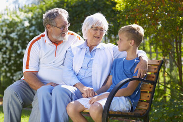 Großeltern und Enkel sitzen auf einer Parkbank - ZEF001113