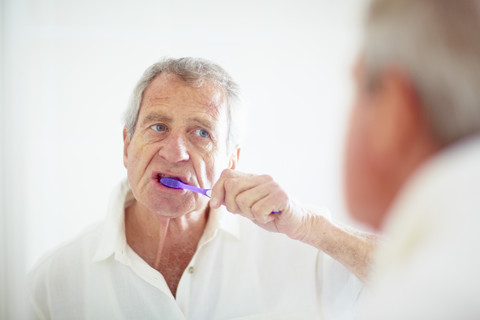 Älterer Mann beim Zähneputzen, lizenzfreies Stockfoto