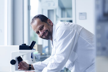 Portrait of smiling chemist at a laboratory - SGF000855
