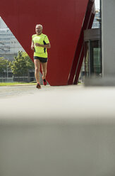 Älterer Mann joggt vor der Arbeit - UUF002005