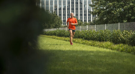 Älterer Mann joggt vor der Arbeit - UUF002012