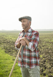 Landwirt steht vor einem Feld - UUF002015