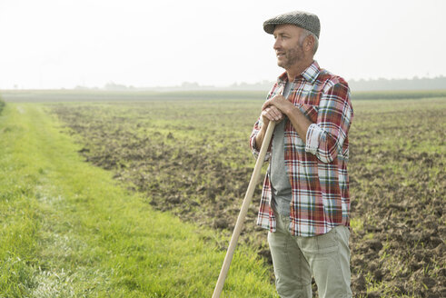 Landwirt steht vor einem Feld - UUF002016