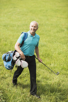 Golfspieler beim Spaziergang auf einer Wiese - UUF002043