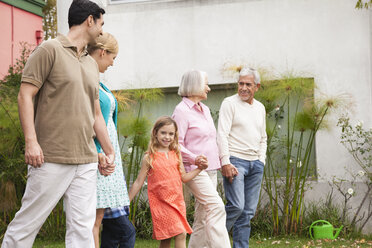 Großfamilie spaziert Hand in Hand im Garten - WESTF020089