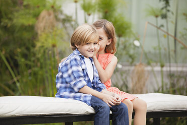 Girl whispering into boy's ear - WESTF020095