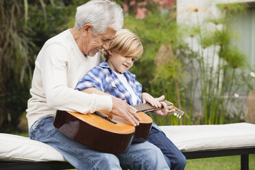 Grandfather and grandson with guitar outdoors - WESTF020102
