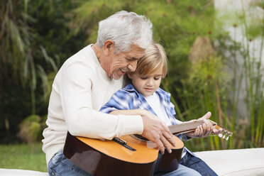 Grandfather and grandson with guitar outdoors - WESTF020103