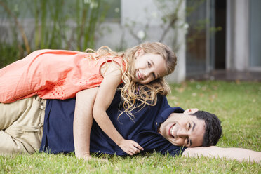 Verspielter Vater und Tochter im Gras liegend - WESTF020114