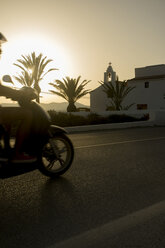 Spain, Balearic Islands, Ibiza, moped rider at sundown - TKF000402