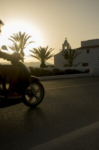 Spanien, Balearische Inseln, Ibiza, Mopedfahrer bei Sonnenuntergang - TKF000402