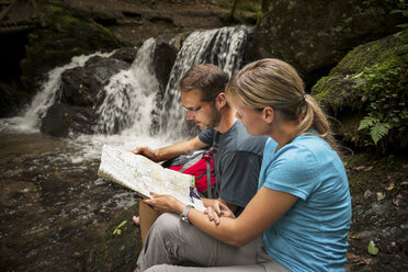 Germany, Rhineland-Palatinate, Moselsteig, Ehrbachklamm, couple reading map at waterfall - PAF000998