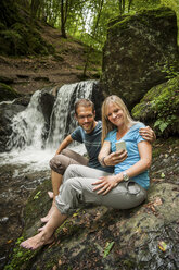 Deutschland, Rheinland-Pfalz, Moselsteig, Ehrbachklamm, Paar macht Selfie am Wasserfall - PAF000999