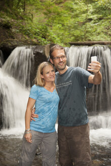 Deutschland, Rheinland-Pfalz, Moselsteig, Ehrbachklamm, Paar macht Selfie am Wasserfall - PAF001001