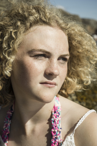Porträt eines jungen Mädchens mit Sommersprossen, das in die Ferne schaut, lizenzfreies Stockfoto