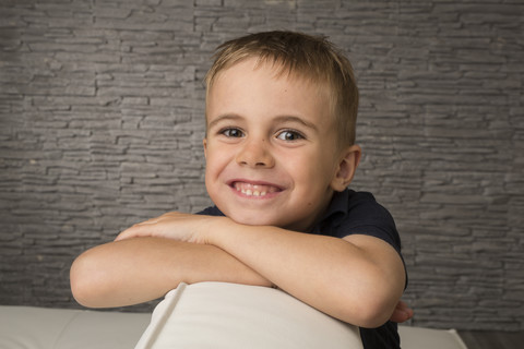 Porträt eines lächelnden Jungen mit verschränkten Armen, lizenzfreies Stockfoto