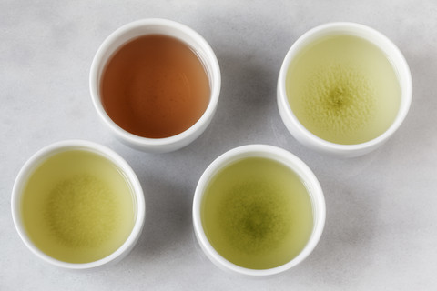Vier Teeschalen mit Sencha, Gyukuro, Hojicha und Genmaicha, lizenzfreies Stockfoto