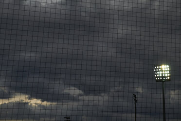 Fußballnetz vor Flutlicht und dunkel bewölktem Himmel - BSCF000441