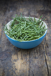 Blue bowl of saltwort, Salicornia, on dark wood - LVF001966