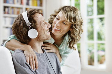 Germany, Hesse, Frankfurt, Adult couple at home listening to music - RORF000088