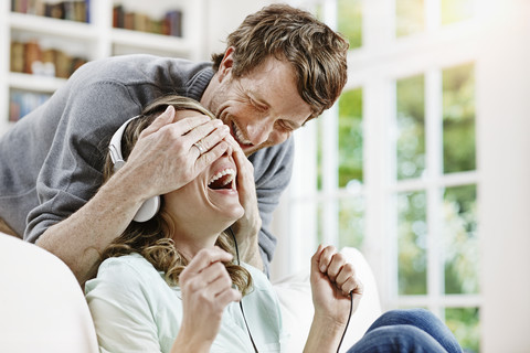 Deutschland, Hessen, Frankfurt, Erwachsenes Paar zu Hause beim Musikhören, lizenzfreies Stockfoto