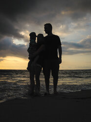 Silhouette einer jungen Familie, Vater, Mutter und Kleinkind, bei Sonnenuntergang an einem Strand in Mexiko - ABAF001510