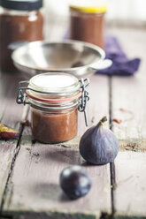 Einmachglas mit Pflaumen-Feigen-Marmelade auf Holz - SBDF001300