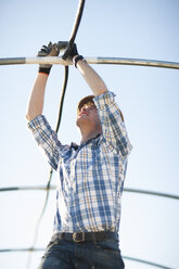 Young man assembling greenhouse - ZEF001204