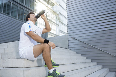 Sportler macht eine Pause und trinkt aus seiner Flasche - MAD000054