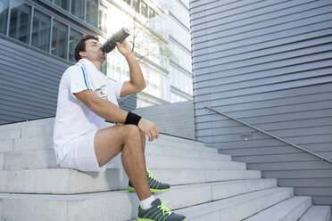 Sportsman having a break drinking out of his bottle - MAD000054