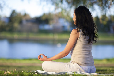 Junge Frau macht Yoga-Übungen in einem Park - ZEF001224