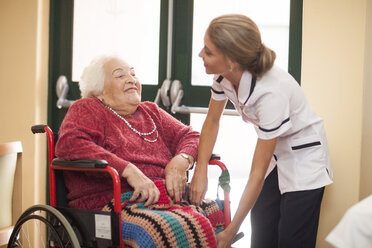 Krankenschwester kümmert sich um ältere Frau im Rollstuhl - ZEF001297