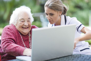 Krankenschwester und ältere Frau benutzen gemeinsam einen Laptop - ZEF001301