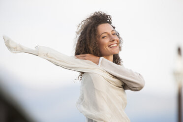 South Africa, Young woman smiling, scarf flying in wind - ZEF001267