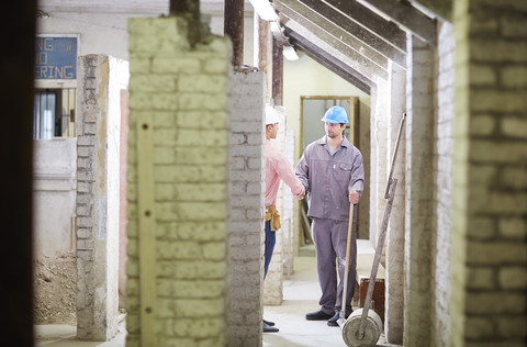 Bauarbeiter und Polier treffen sich auf der Baustelle, lizenzfreies Stockfoto