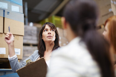 Woman with clipboard in warehouse - ZEF001433