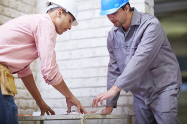 Construction worker and foreman dicussing building plan - ZEF001835