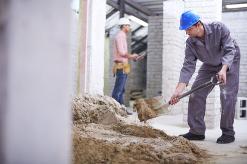 Bauarbeiter mischt Beton mit Schaufel - ZEF001839